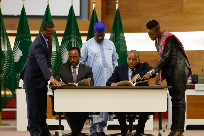 Redwan Hussein (seated left), representative of the Ethiopian government, and Getachew Reda (seated right), representative of the Tigray People's Liberation Front, sign a peace agreement between the two parties in Pretoria, South Africa, Wednesday.