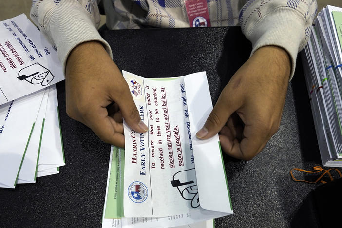 A Harris County election worker prepares mail-in ballots to be sent to Texas voters ahead of the 2020 election. After a GOP-backed law in 2021 changed rules for mail ballots, rejections spiked in this year's state primaries.