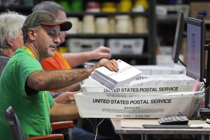 Election workers scan mail-in ballots at the Allegheny County Election Division warehouse in Pittsburgh on Thursday. The Pennsylvania Supreme Court has ordered local officials to hold off on counting ballots that arrive on time in envelopes without handwritten dates or with incorrect dates.