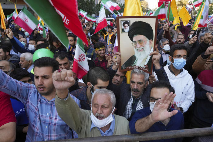 Demonstrators chant slogans Friday as one of them holds up a poster of Iranian Supreme Leader Ayatollah Ali Khamenei during a demonstration in front of the former U.S. Embassy in Tehran, Iran.