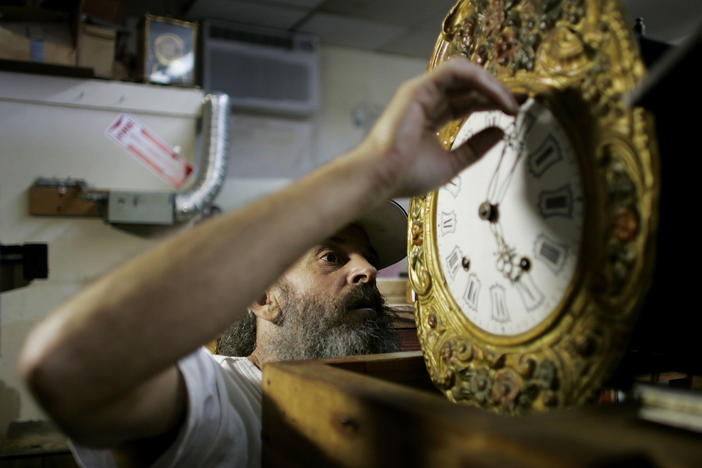 Mark Brown repairs a clock at Brown's Old Time Clock Shop in Plantation, Florida in 2007.