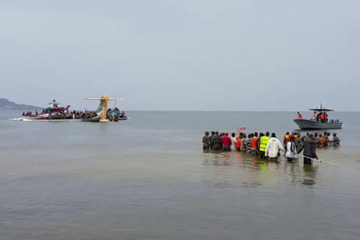 Rescuers in boats and standing in the water are seen around the tail fin of a crashed Precision Air passenger aircraft on the shores of Lake Victoria in Bukoba, in western Tanzania on Sunday.