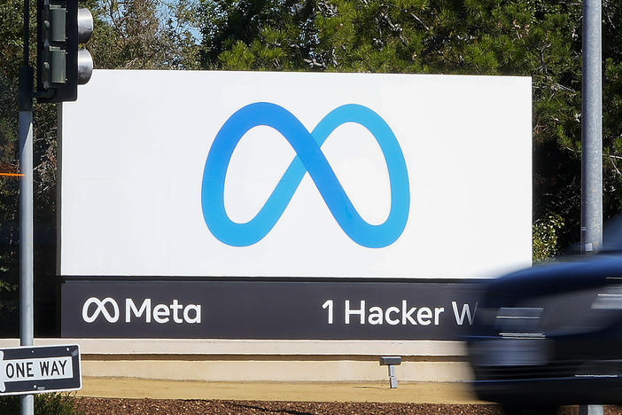 A car passes Facebook's new Meta logo on a sign at the company headquarters in Menlo Park, Calif.