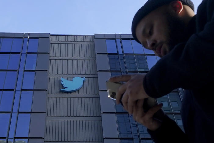 People walk outside Twitter headquarters in San Francisco, Friday, Nov. 4, 2022.