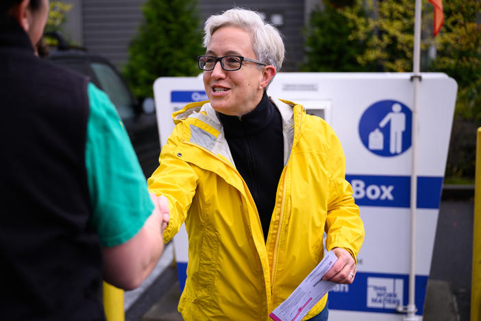 Democratic nominee for governor Tina Kotek greets an employee of a local grocery store before casting her ballot at a ballot drop box on Nov. 2, in Portland, Ore.