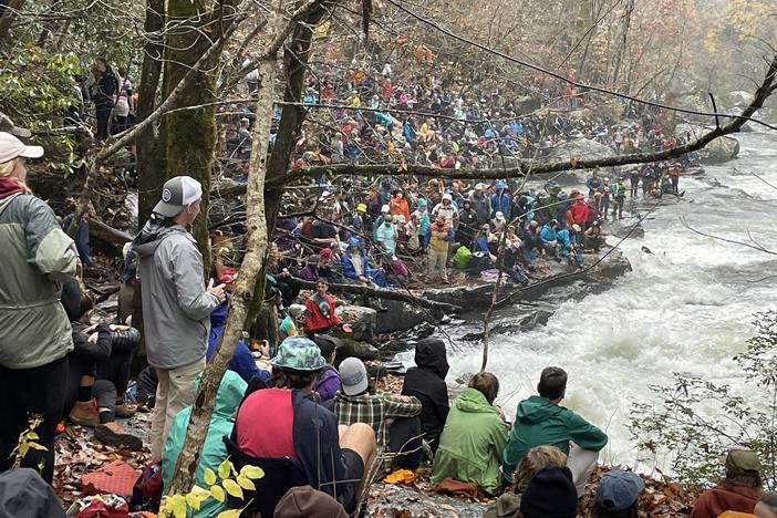 People crowd the steep banks of the Green River near Saluda, N.C., to watch participants in the Green Race, an event that organizers claim is the largest extreme kayak race in the world.