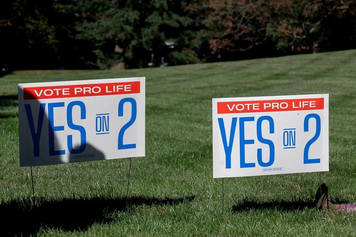 A child sits next to Yes on 2 signs during a rally encouraging voters to vote yes on Amendment 2, which would add a permanent abortion ban to Kentucky's state constitution, on the steps of the Kentucky State Capitol in Frankfort, Ky. on Oct. 1, 2022.