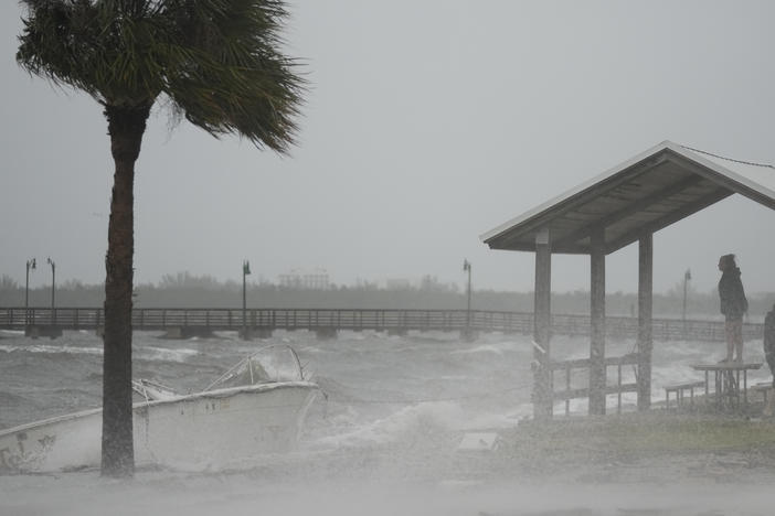 People brave rain and heavy winds to visit the waterfront along the Jensen Beach Causeway, as conditions deteriorate with the approach of Hurricane Nicole, Wednesday, Nov. 9, 2022, in Jensen Beach, Fla.