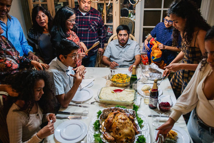 The Broughton family prepares for their dinner prayers during a gathering on November 26, 2020 in Los Angeles, California. Prices for Thanksgiving staples like turkey are on the rise this year, thanks to inflation.