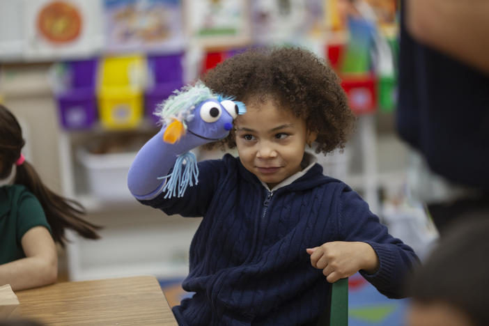 First-grader Rylee plays with a puppet during class.