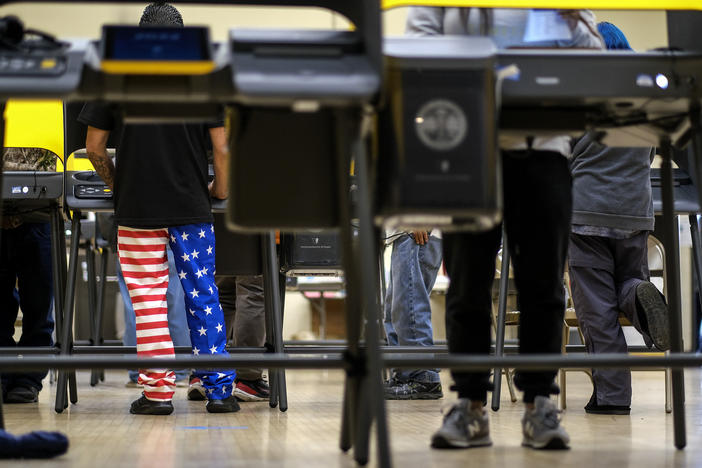 A man wearing American flag pants casts his ballot at a voting station in Los Angeles on Tuesday. On Wednesday, the LA County district attorney dropped charges against the CEO of Konnech, which makes scheduling software for poll workers.