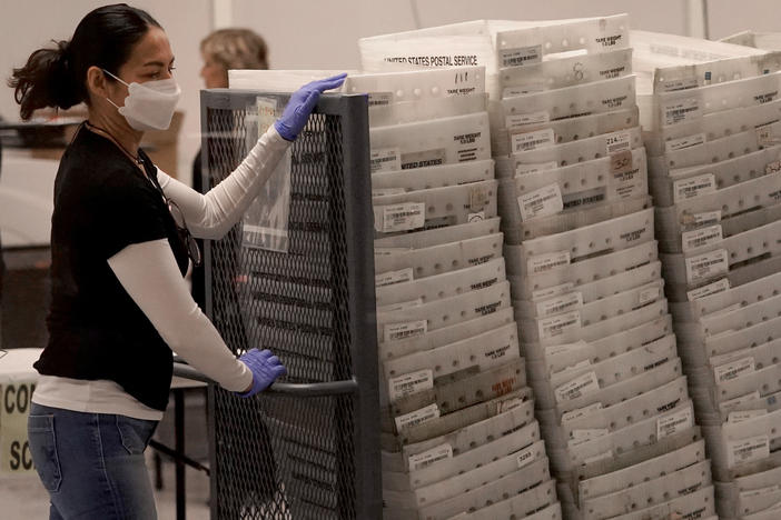 An election worker arrives with ballots to be tabulated inside the Maricopa County recorder's office in Phoenix on Wednesday.
