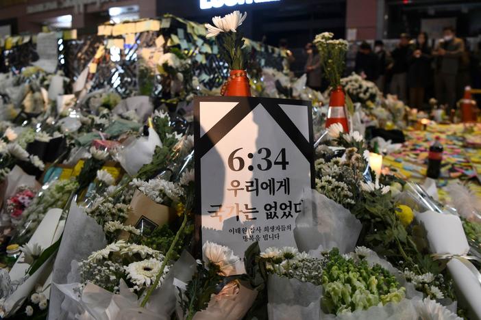 Among the flowers left at the alleyway where more than 150 people were killed in a crowd crush, a poster references the time — 6:34 p.m. — when police received the first call warning of the dangerous crowd size, about four hours before the crush turned deadly.