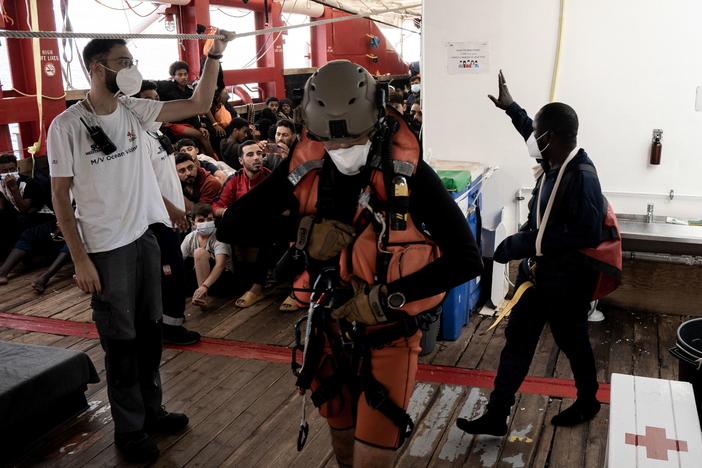 A man with an arm injury and in need of urgent medical care, right, waves to fellow migrants before he is flown by helicopter by the French Army from the Ocean Viking rescue ship on Thursday. French authorities evacuated several migrants from the ship ahead of the ship docking in Toulon on Friday.