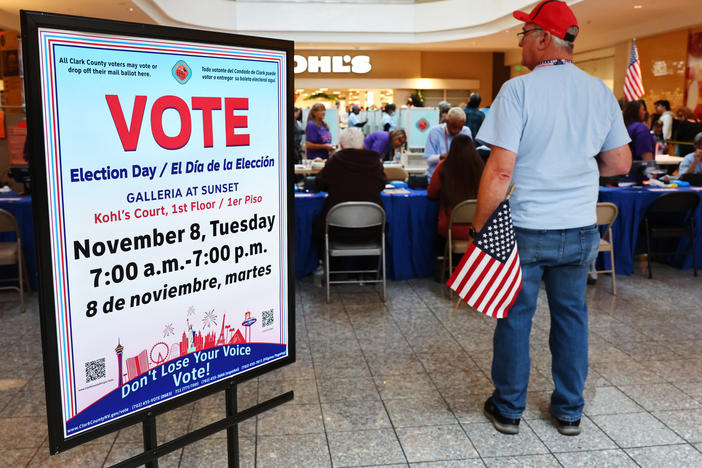 An election worker holds an American flag at a polling place at Galleria At Sunset in Henderson, Nevada on Nov. 8.