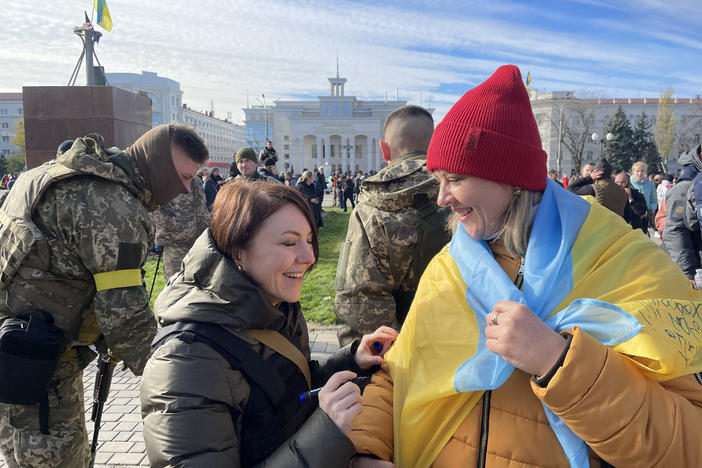 Hanna Malyar, Ukraine's deputy defense minister (center), signs a Ukrainian flag belonging to a local resident in Kherson on Monday. "Ukraine's success depends on two points," Malyar told NPR. "First our strength, our ability to fight. And second, the weapons that we receive from our partners," referring to the United States and other Western nations.