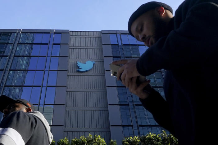 People walk outside Twitter headquarters in San Francisco, Friday, Nov. 4, 2022.