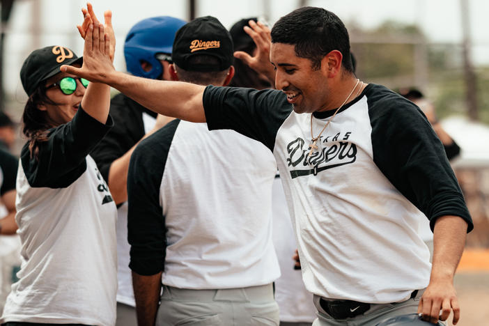 The Dingers' Matthew Carrillo shares a high five with a teammate.