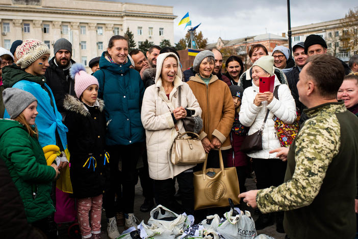 Local people react to a volunteer from Odesa distributing aid on the main square in front of the Regional Administration Building in Kherson on Wednesday.