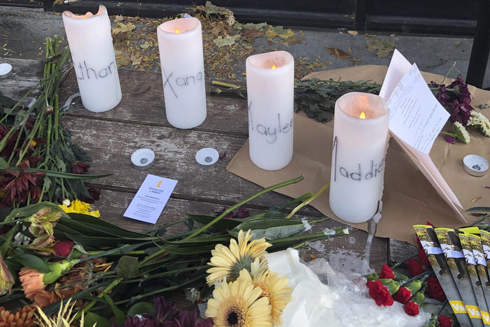 Candles and flowers are left at a make-shift memorial honoring four slain University of Idaho students outside the Mad Greek restaurant in downtown Moscow, Idaho, on Tuesday.