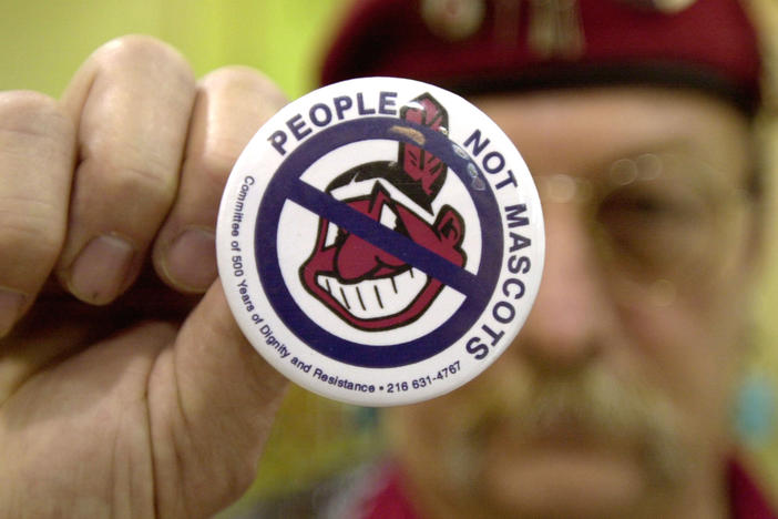 Powwow attendee Sonny Hensley holds an anti-mascot button to protest using Indians as mascots for sports teams at the 2003 New Years Eve Sobriety Powwow in Columbus, Ohio.