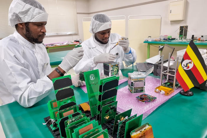Bonny Omara (left) works with Edgar Mujuni at Japan's Kyushu Institute of Technology on the satellite that will be used to observe land conditions in Uganda.