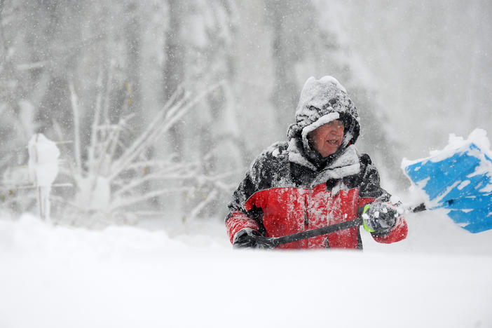 Tom Dee uses a shovel to dig out after an intense lake effect snowstorm impacted the area on Friday in Hamburg, N.Y.