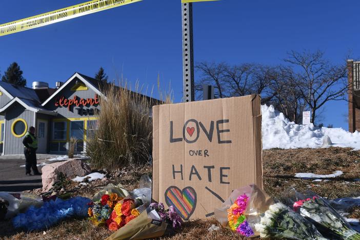 Bouquets of flowers and a sign reading "Love Over Hate" are left near Club Q, the LGBTQ nightclub in Colorado Springs, Colorado, after a shooting on Sunday.