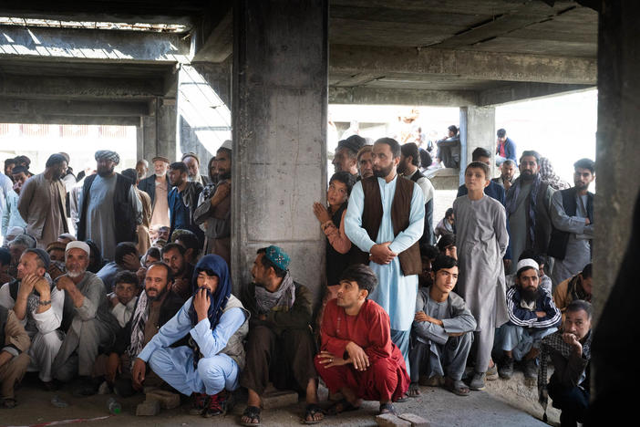 Afghans wait for food assistance from the World Food Programme in Kabul in October.