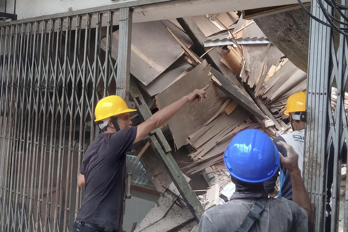 Workers inspect a store damaged during an earthquake in Cianjur, West Java, Indonesia, Monday, Nov. 21, 2022.