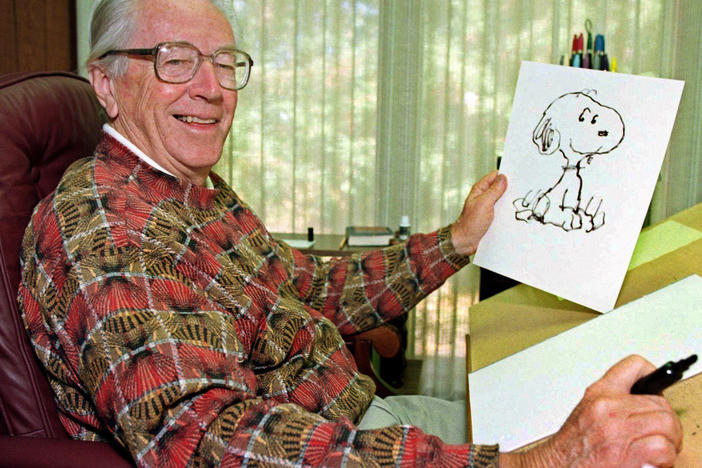 Cartoonist Charles Schulz poses with a sketch of Snoopy in his office in Santa Rosa, Calif. Schulz, who died shortly after his retirement in 2000, would have turned 100 on Nov. 26.
