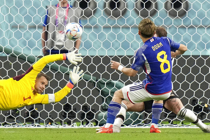 Japan's Ritsu Doan scores his side's first goal Wednesday against Germany's goalkeeper Manuel Neuer during a World Cup soccer match at the Khalifa International Stadium in Doha, Qatar.