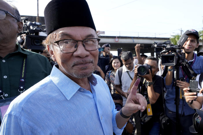 Opposition leader Anwar Ibrahim shows his inked finger to the media after voting at a polling station in Seberang Perai, Penang state, Malaysia on Nov. 19, 2022.
