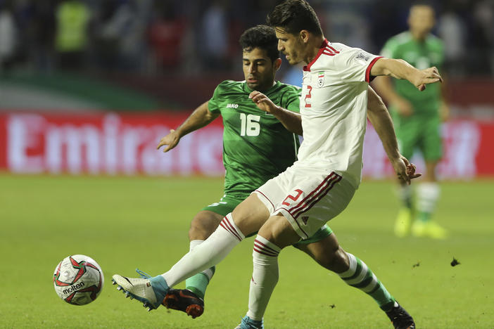 Iranian soccer player Voria Ghafouri (right), then a member of the national soccer team, fights for the ball with Iraqi midfielder Hussein Ali during the AFC Asian Cup soccer match in Dubai in 2019. The semiofficial Fars and Tasnim news agencies reported on Thursday that Iran arrested Ghafouri for insulting the national soccer team and criticizing the government.