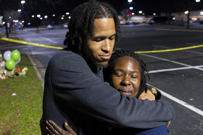 Cameron Bertrand hugs LaShana Hicks at a Tuesday memorial for those killed in a fatal shooting at a Walmart Supercenter in Chesapeake, Va.