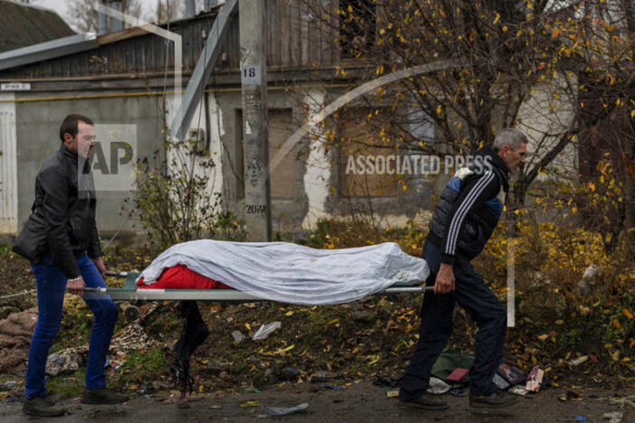 City workers collect the body of a man in Kherson, southern Ukraine, Friday, Nov. 25, 2022. The man died during a Russian attack on Thursday. (AP Photo/Bernat Armangue)