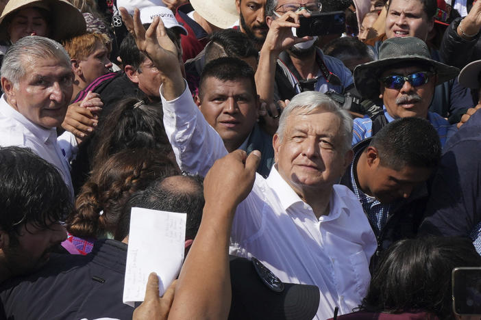 Mexican President Andrés Manuel López Obrador, right, waves during a march in support of his administration in Mexico City on Sunday.
