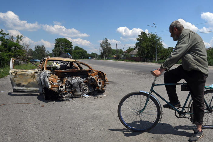 Oleksandr Breus, a Ukrainian and onetime French legionnaire, was killed next to his car during the Russian invasion. Oleksandr Holod, who says he witnessed it from his window, describes events as he rides his bike past the charred remains of the vehicle near Nova Basan, Chernihiv Oblast, Ukraine on June 28.