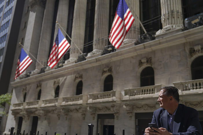 A trader stands outside the New York Stock Exchange. Stocks fell Monday, giving back some of the huge gains made last week.