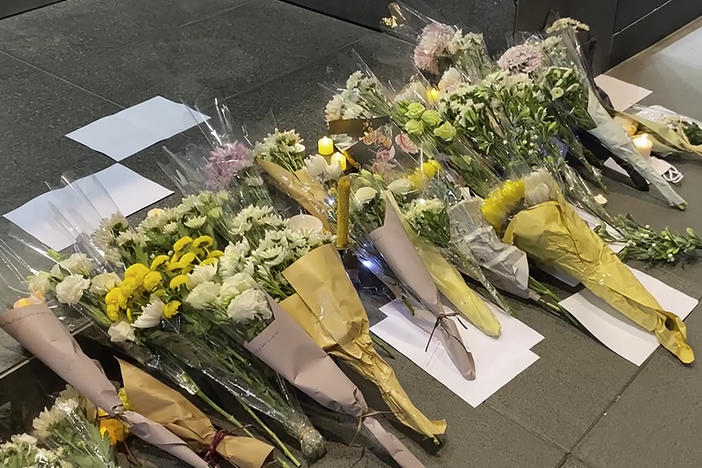 Blank white papers and flowers are laid down during a commemoration for victims of a recent Urumqi deadly fire in Central in Hong Kong, Monday, Nov. 28, 2022.