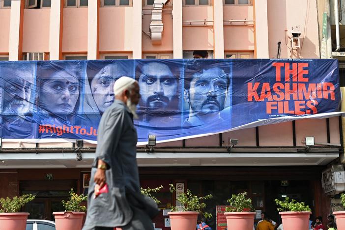 A man walks past a banner of Bollywood movie <em>The Kashmir Files</em> outside a cinema in the old quarters of Delhi on March 21, 2022.