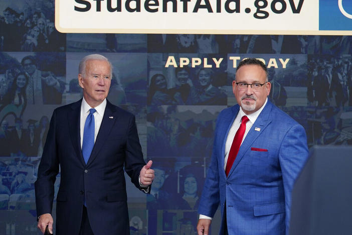 President Joe Biden answers questions with Education Secretary Miguel Cardona in October as they leave an event about the student debt relief portal.