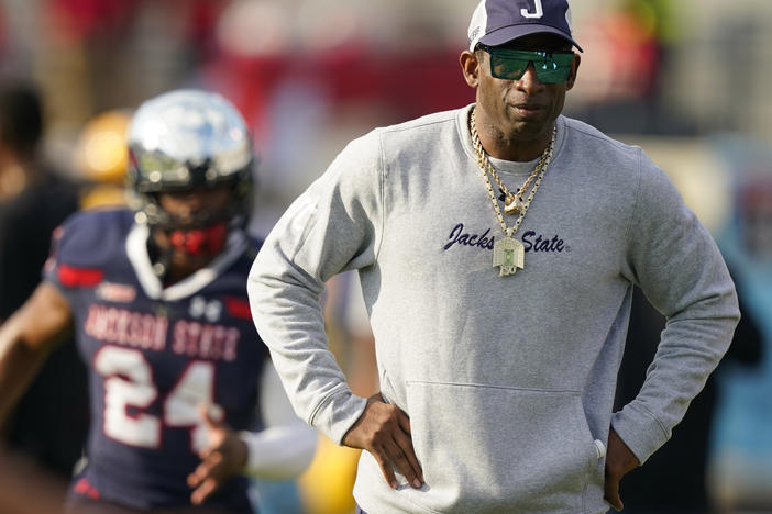 Jackson State coach Deion Sanders watches players preparing for the Southwestern Athletic Conference championship NCAA college football game against Southern on Saturday in Jackson, Miss. Sanders is taking over as coach at Colorado, bringing his charisma and larger-than-life persona to a beleaguered Pac-12 program that's plunged to the bottom of college football.
