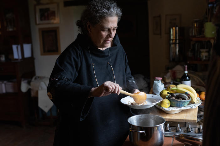 Gloria Lucchesi cooks some local beans that she prepared using the cooking containers, on Nov. 12, in San Casciano dei Bagni, Italy.