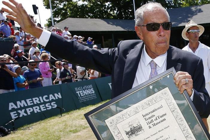 Nick Bollettieri holds his plaque as he waves to the crowd in 2014 after his induction into the International Tennis Hall of Fame in Newport, R.I.