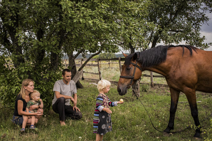 Olga and Nikolay Grinik with their son, Kirill (left), and daughter, Miroslava (right), in Avdiivka, in eastern Ukraine's Donetsk region, in July 2018. The family lived about 50 yards away from a Ukrainian front-line military position in old Avdiivka. They owned the only horse in town, Lastochka (Swallow), and made extra money giving cart rides to children in downtown Avdiivka.