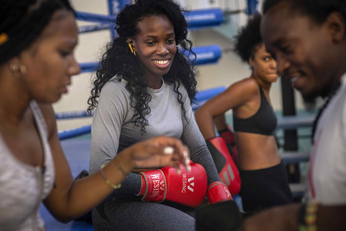 Boxer Legnis Cala, center, talks with fellow female boxers during a training session in Havana, Cuba, Monday, Dec. 5, 2022. Cuban officials announced on Monday that women boxers would be able to compete for the first time ever.