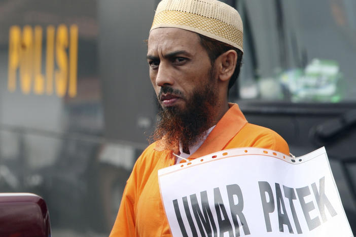 Convicted militant Umar Patek pauses during the police reenactment of the scenes leading to the 2002 Bali bombing, in Denpasar, Bali Indonesia, on Oct. 20, 2011.