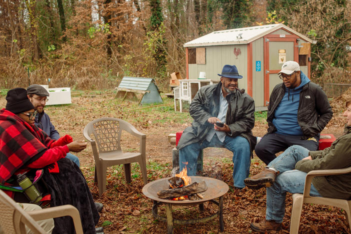 The "congregation" gathers on a Sunday morning in early November at the Battlefield Farm & Gardens in Knoxville, Tenn. Pastor Chris Battle, center, left the Baptist church and started the community garden and a free food delivery as a way to build community and "do church differently."