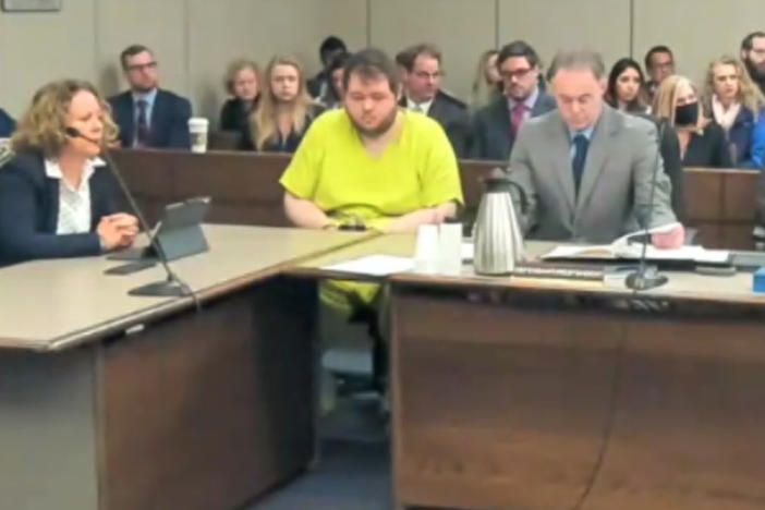 In this image taken from El Paso County District Court video, Anderson Lee Aldrich, 22 (center) sits during a court appearance in Colorado Springs, Colo., on Tuesday. According to newly unsealed court documents, Aldrich was also charged with felony crimes in June 2021, but the case was dismissed.